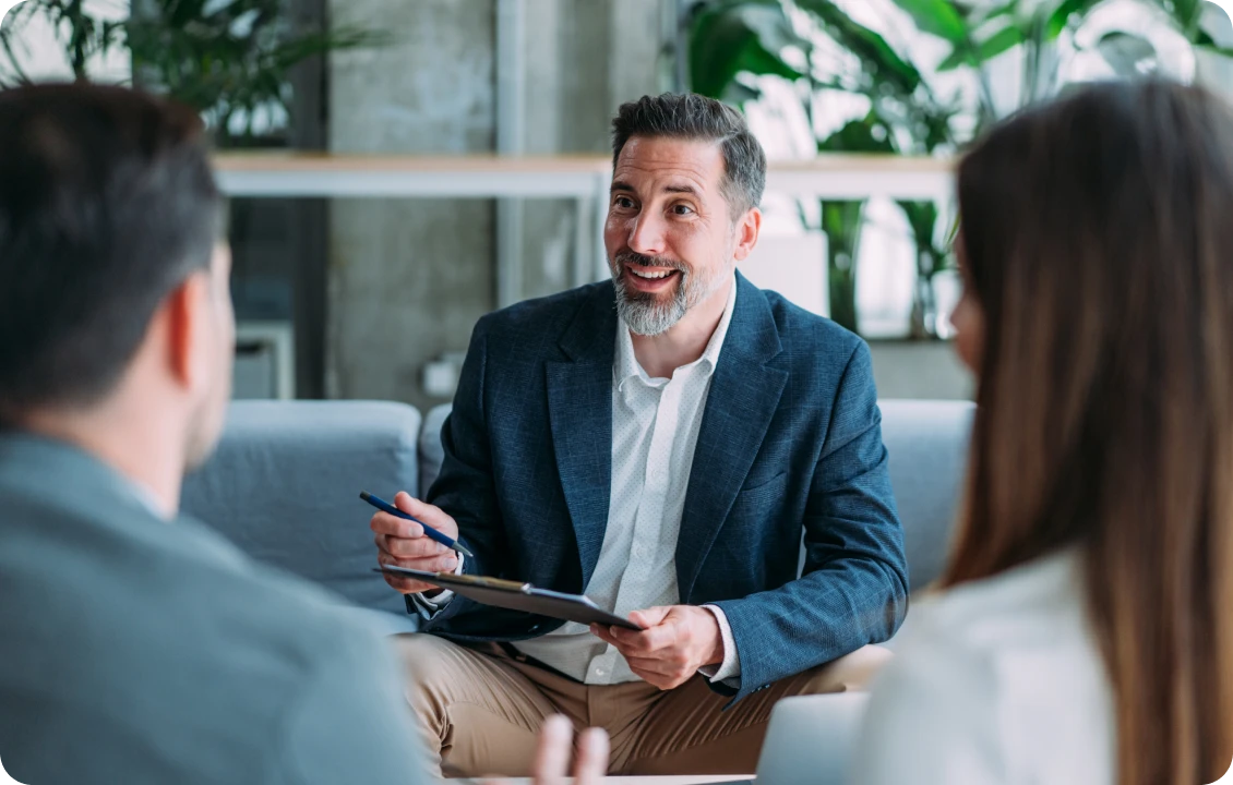 Man discussing with two people in office.
